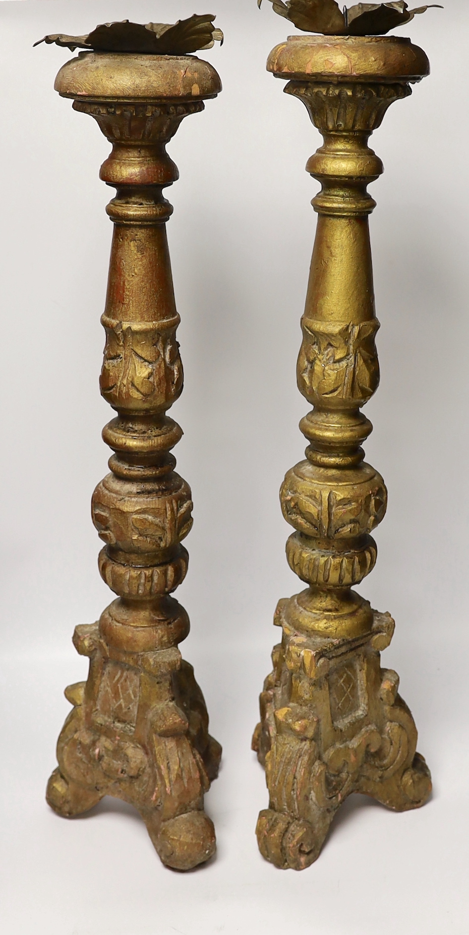A pair of gilt and carved wooden altar sticks, 71cm